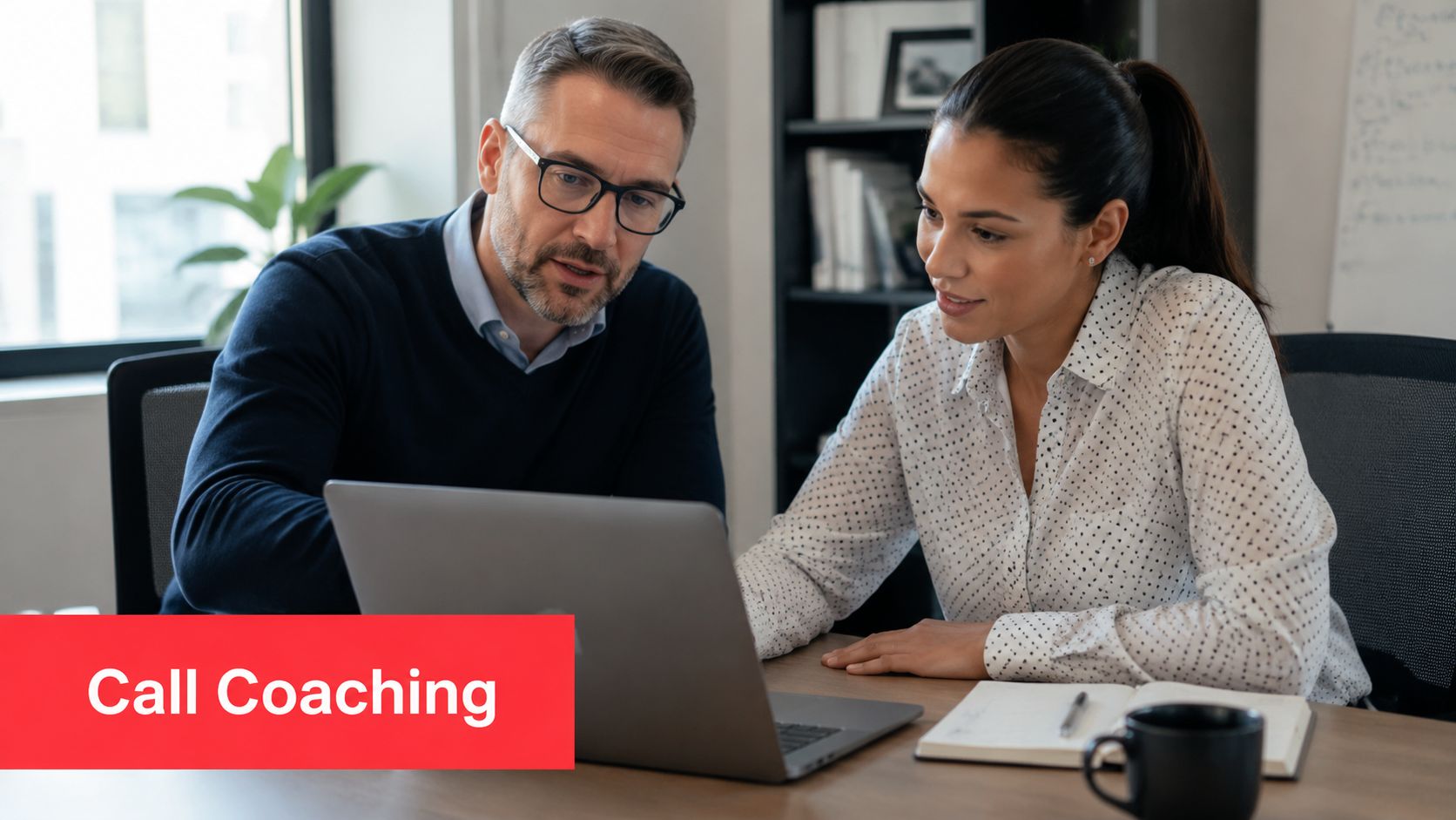 A professional manager provides call coaching to an employee while reviewing data on a laptop in office.
